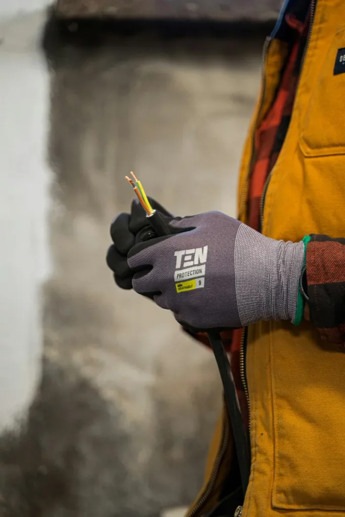 Electricien tenant en main des fils électriques